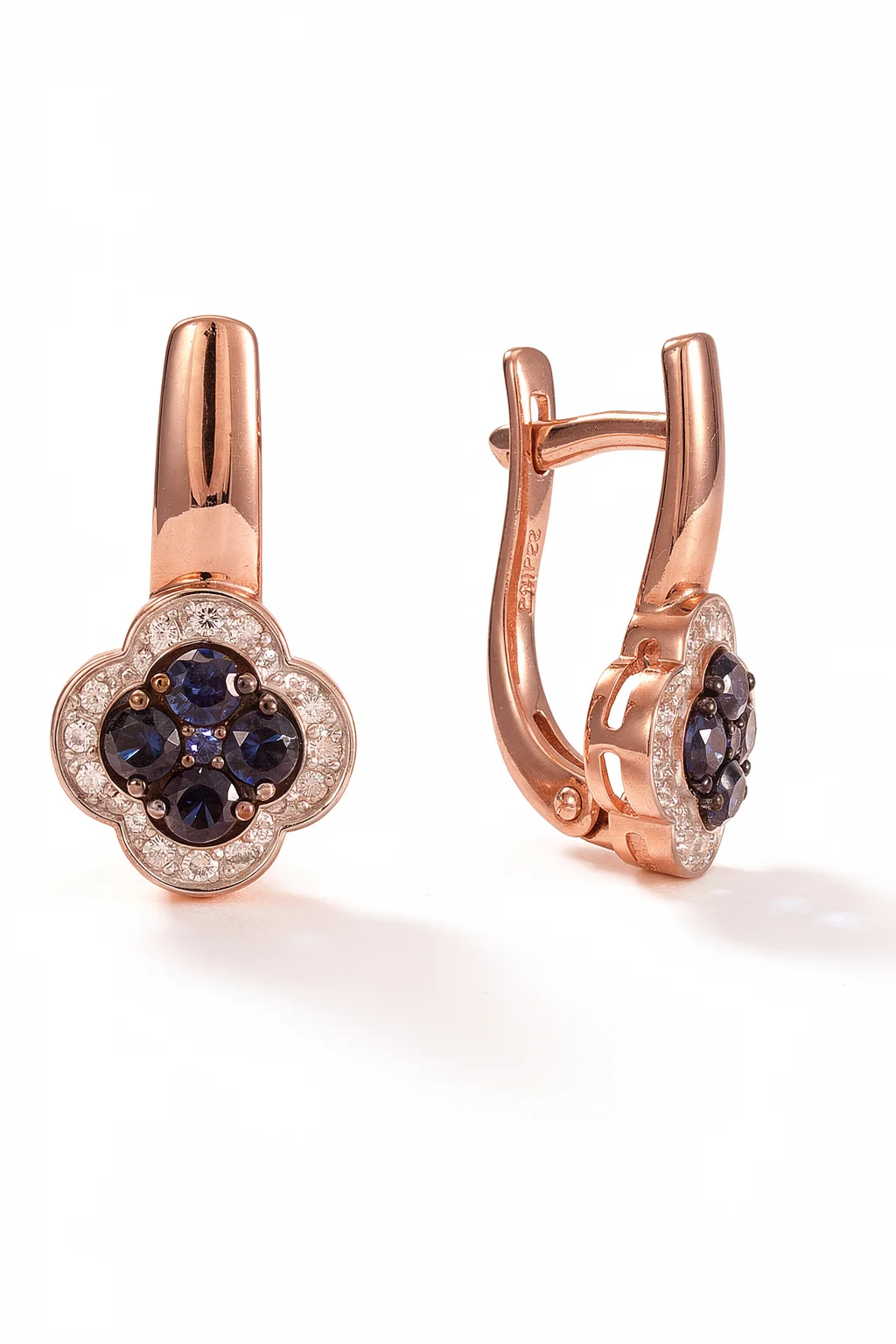 Золотые серьги с темными камнями в цветочной форме.