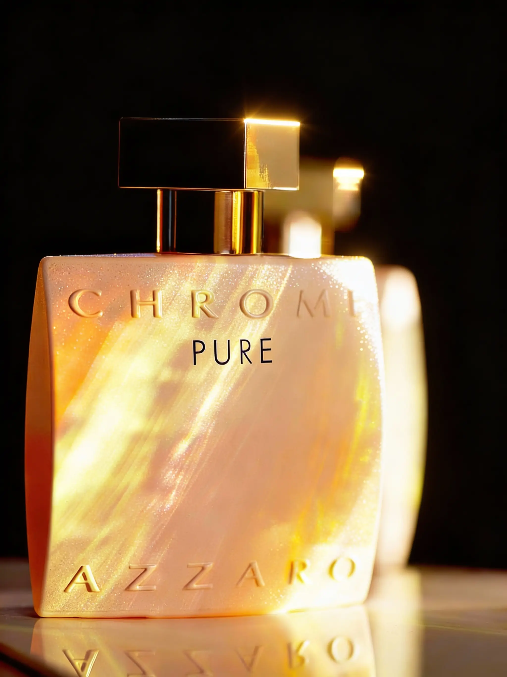 Флакон духов Azzaro в теплых золотистых тонах с подсветкой.