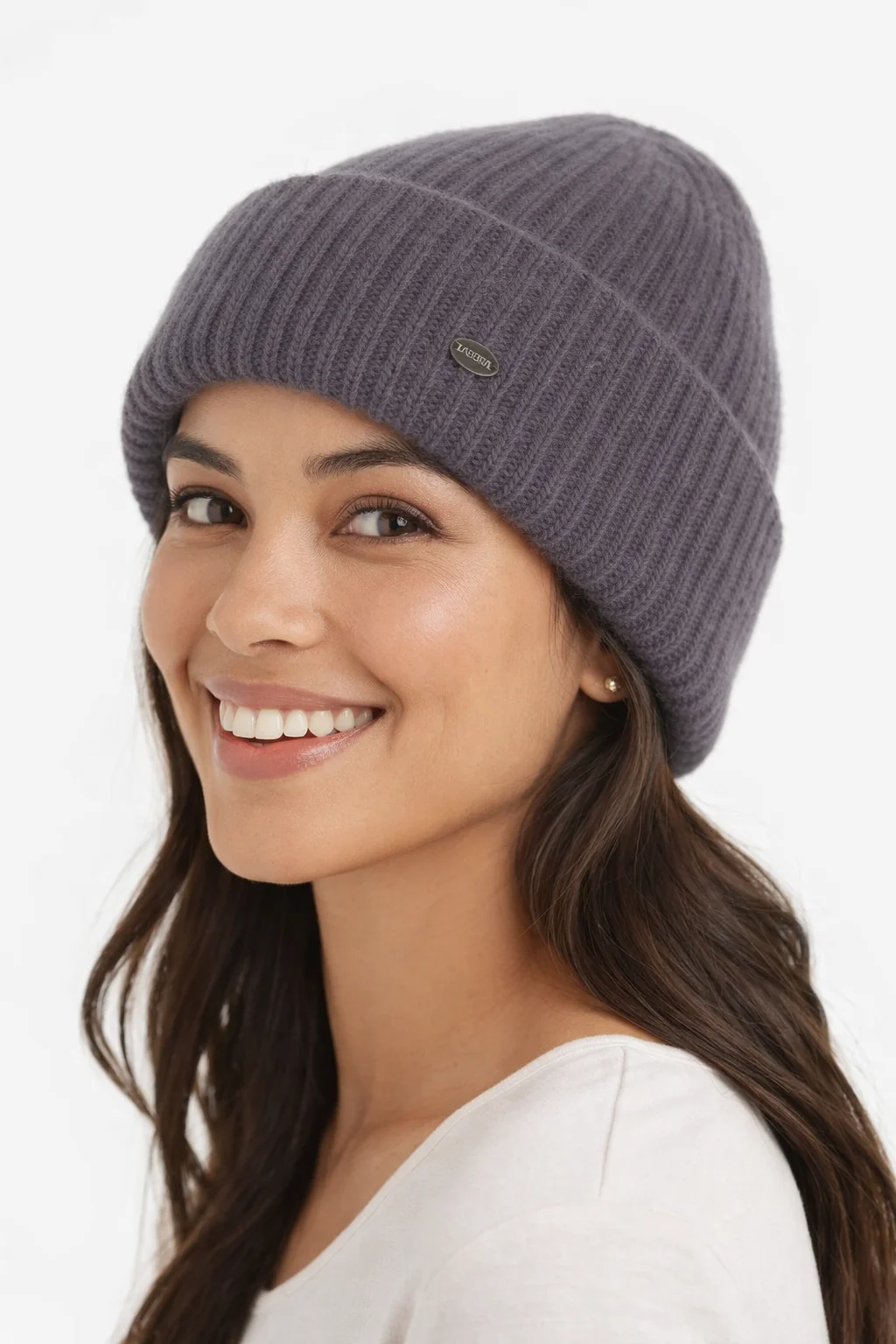 Девушка в шапке улыбается на светлом фоне, портрет.